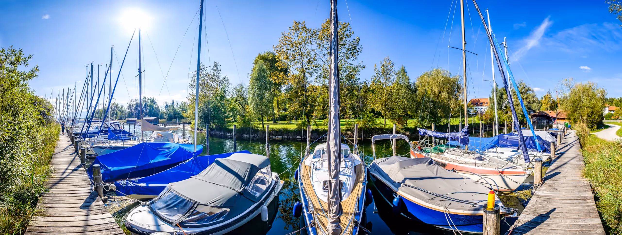 Motorboote und Segelboot im Yachthafen
