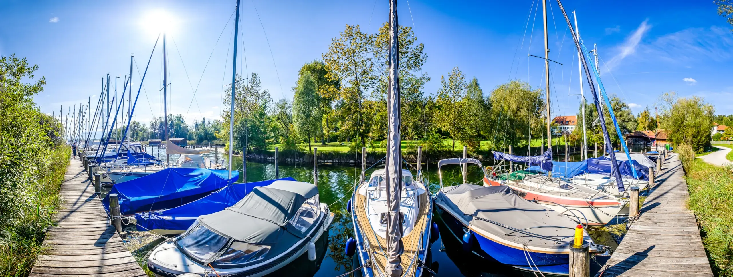 Motorboote und Segelboot im Yachthafen